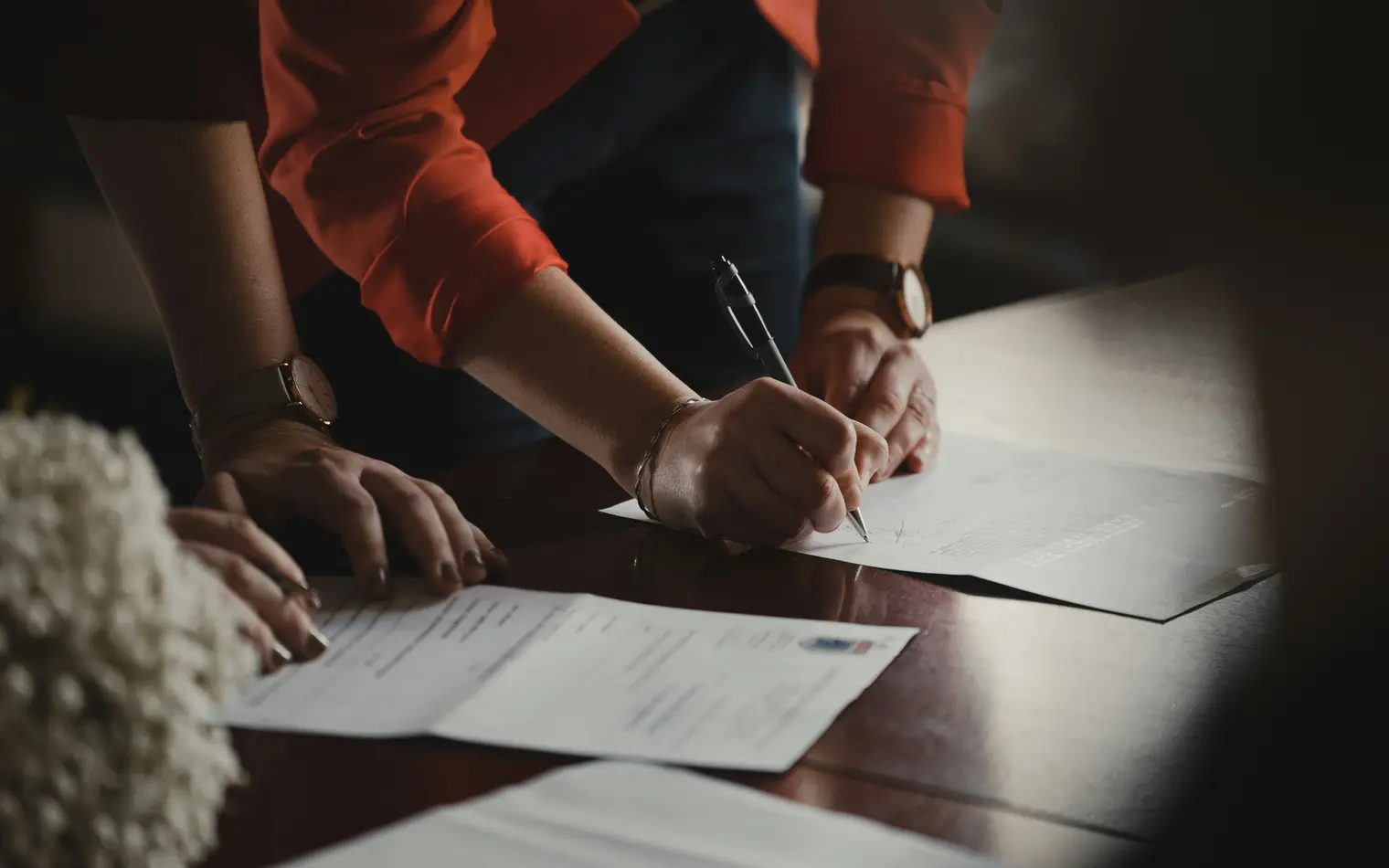 Dos personas firmando la documentación de una compraventa